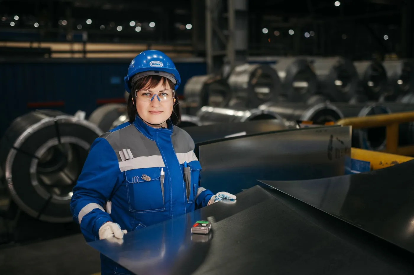 Worker inspecting metal sheets